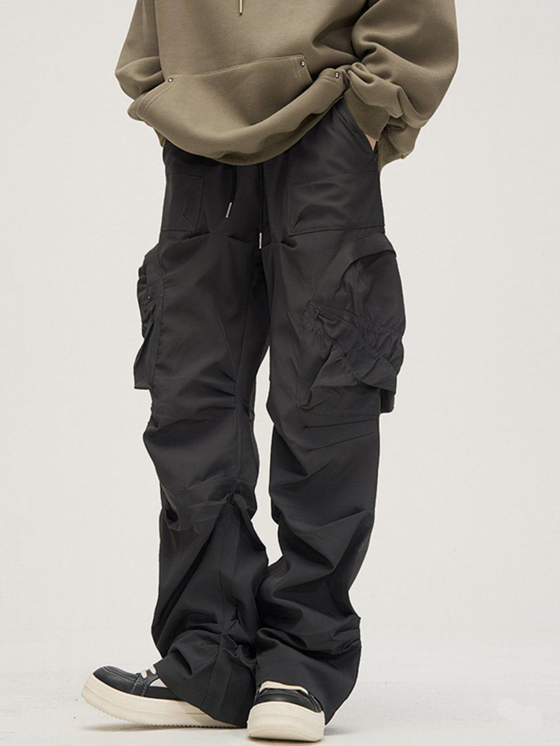 TALISHKO cargo pants with a wrinkle texture and large pockets, styled casually with sneakers.