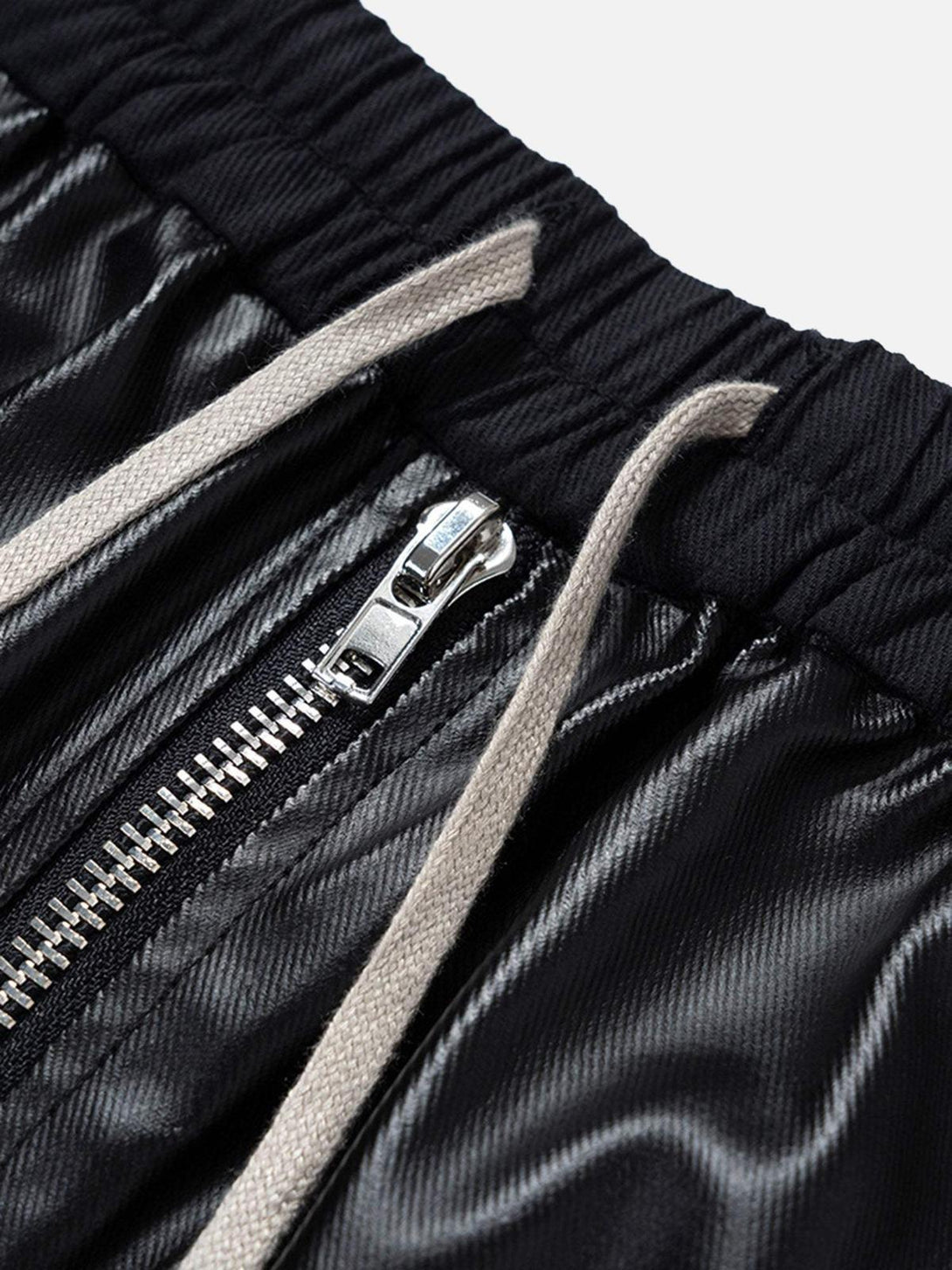 A tight crop highlighting the drawstring and zipper detail on TALISHKO's wide-leg flared pants.