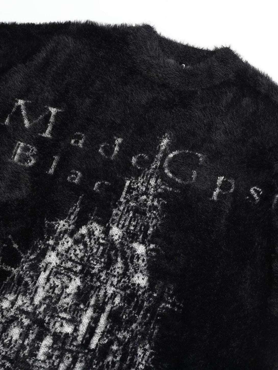 Intricate look at TALISHKO's black sweater, featuring a unique print on plush velvet fabric.