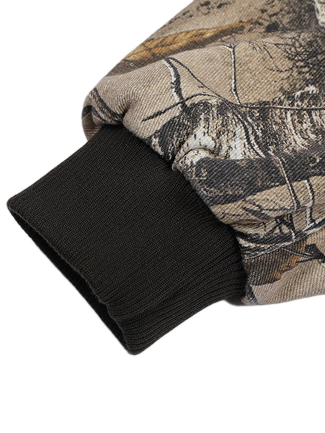 A close-up of the ribbed cuff on a TALISHKO leaf camouflage bomber jacket, highlighting texture.