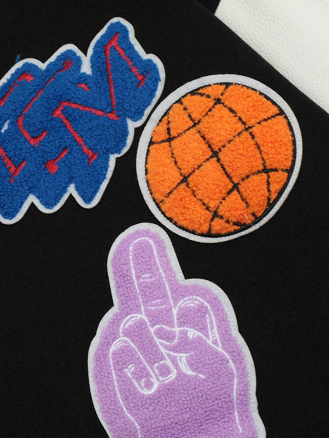 A close-up of TALISHKO bomber jacket's textured embroidered patches, highlighting unique designs.