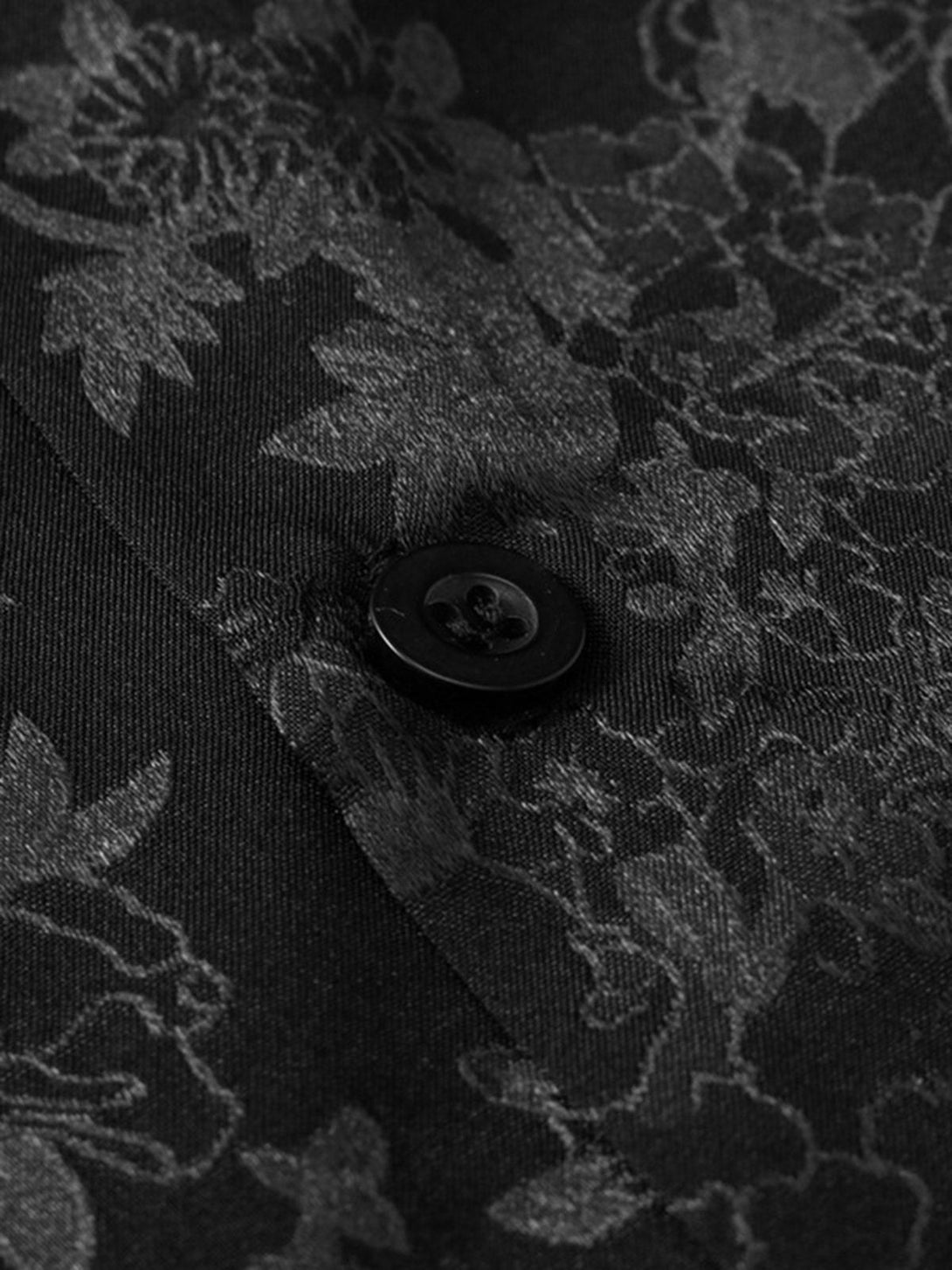 Intricate look at TALISHKO black vintage shirt's leaf pattern and button detail.