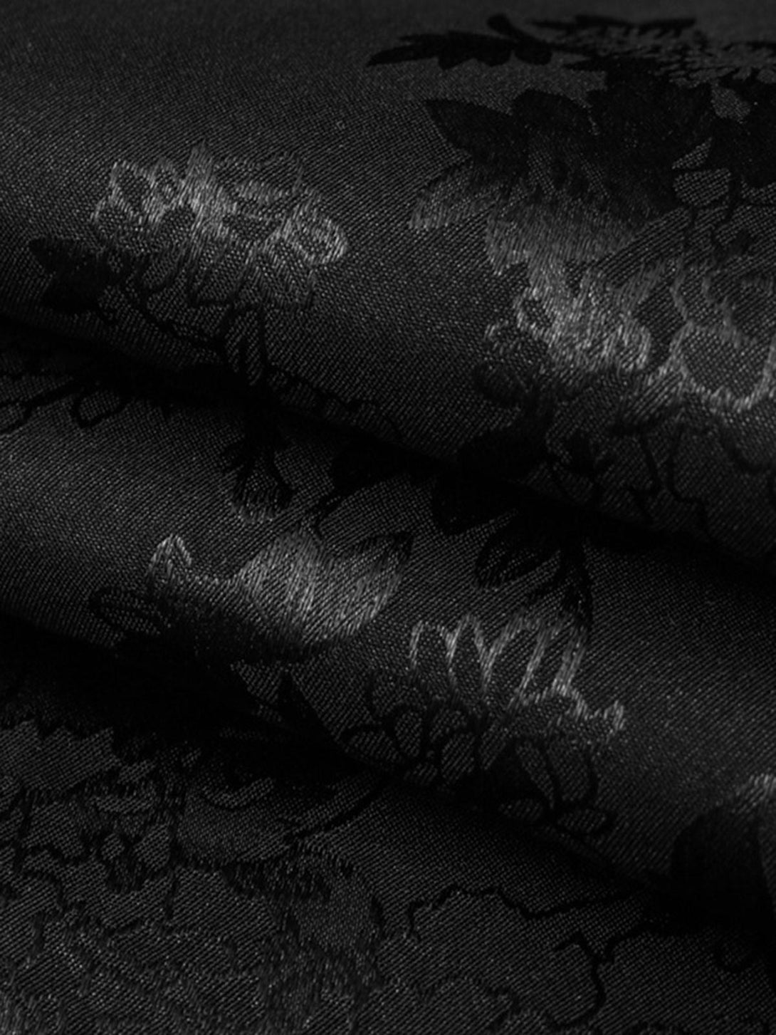 Textured fabric with leaf pattern showcased on TALISHKO black vintage shirt material.