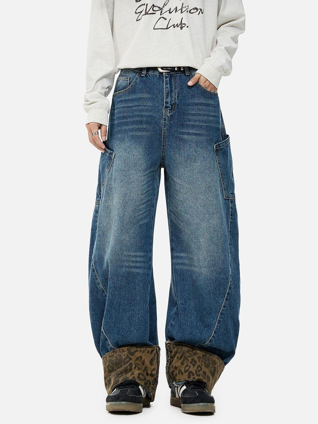 Model wearing TALISHKO jeans with bold leopard print cuffs and a relaxed, wide-leg style.