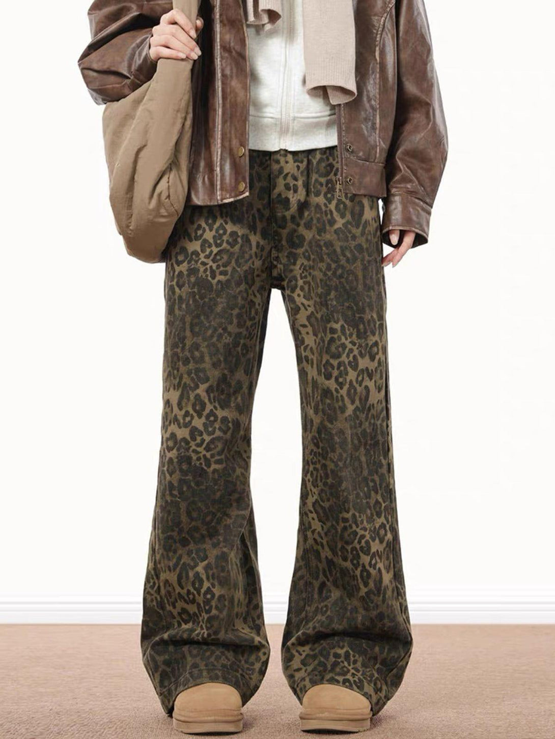 TALISHKO's leopard print jeans paired with a brown leather jacket, showcasing a trendy outfit.