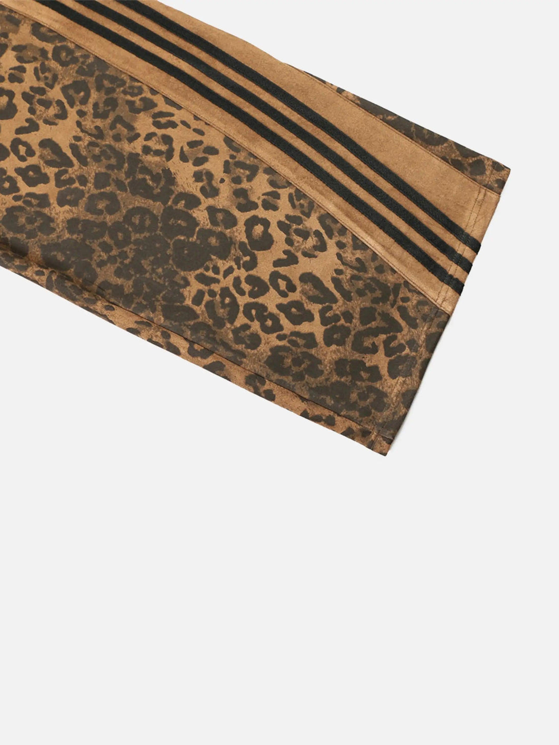 Focusing on the bold leopard pattern of TALISHKO sweatpants, highlighting their unique texture.