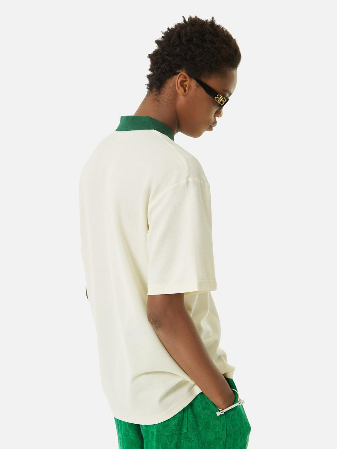 Model in a beige polo shirt with green collar by TALISHKO, paired with green shorts for a fresh look.