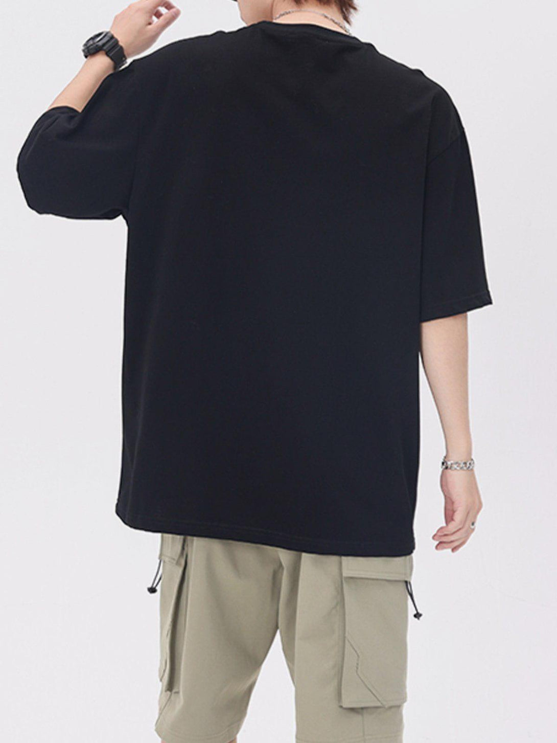 Back view of a black TALISHKO tee paired with beige cargo shorts, highlighting its relaxed fit.