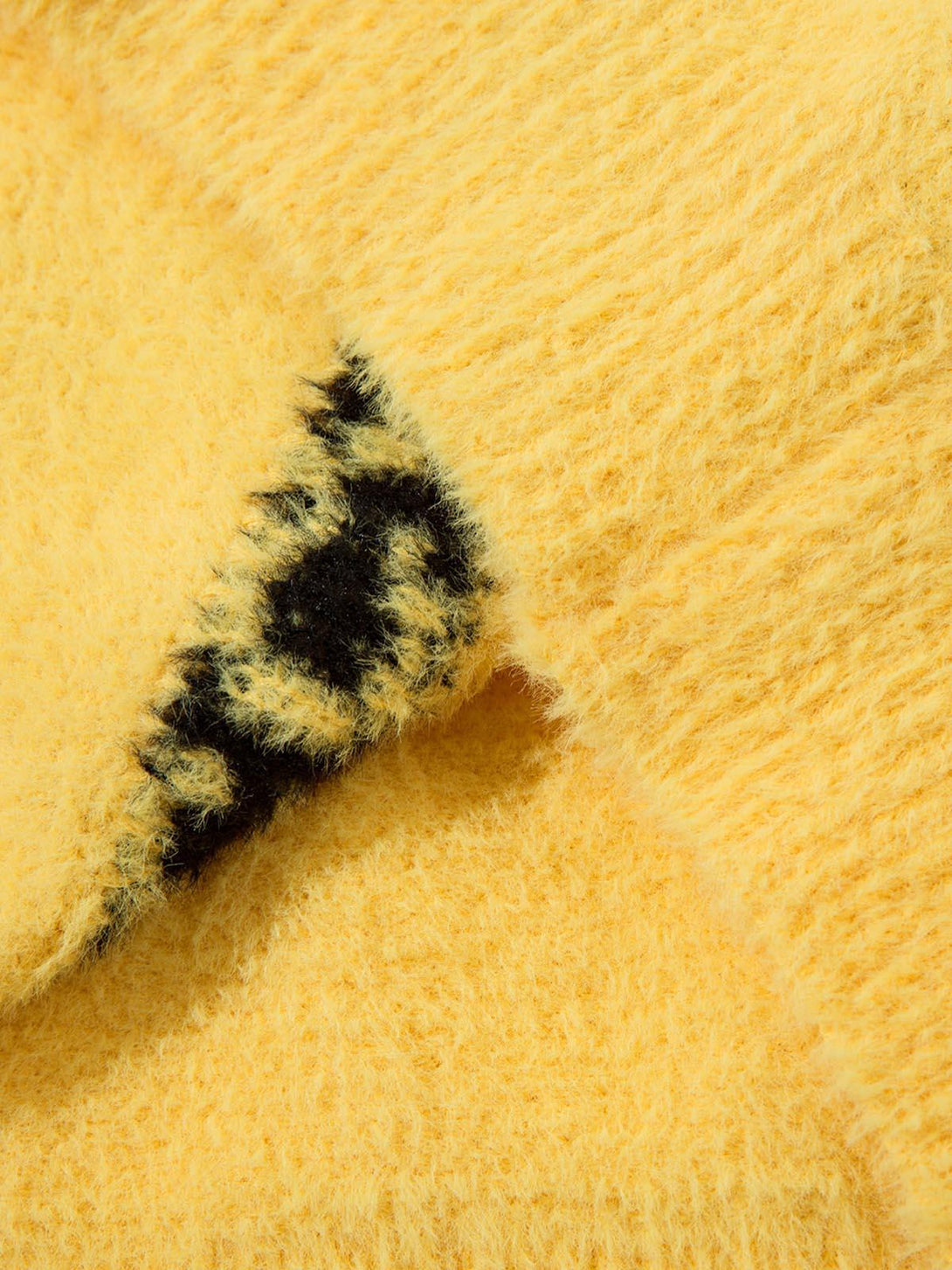 Texture and pattern showcased on a yellow sweater by TALISHKO, highlighting its plush feel.