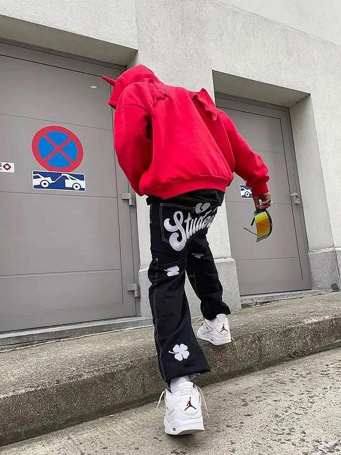 Back view of TALISHKO's baggy jeans with lucky clover embroidery, paired with a bold hoodie.