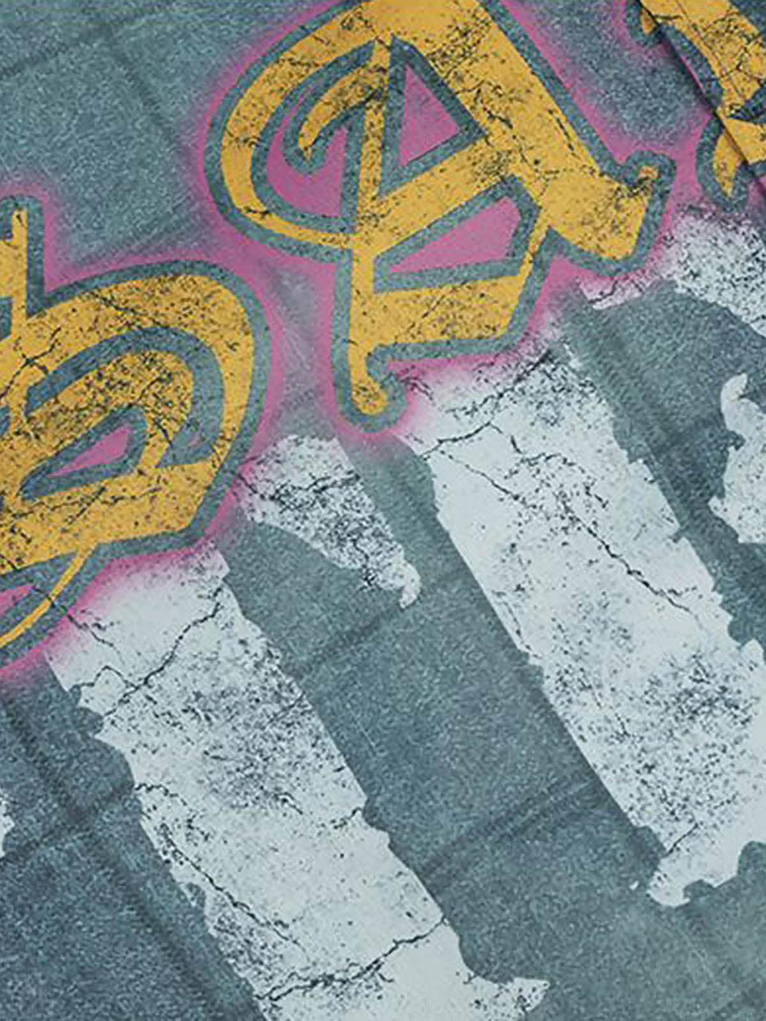 A close-up of TALISHKO's quilted bomber jacket, featuring bold yellow lettering and textured fabric.