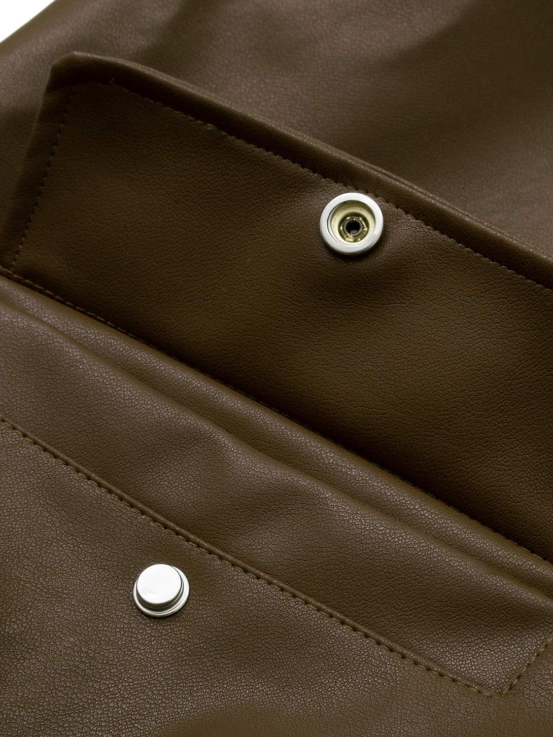 Intricate look at the snap closure detail on a TALISHKO leather bomber jacket.