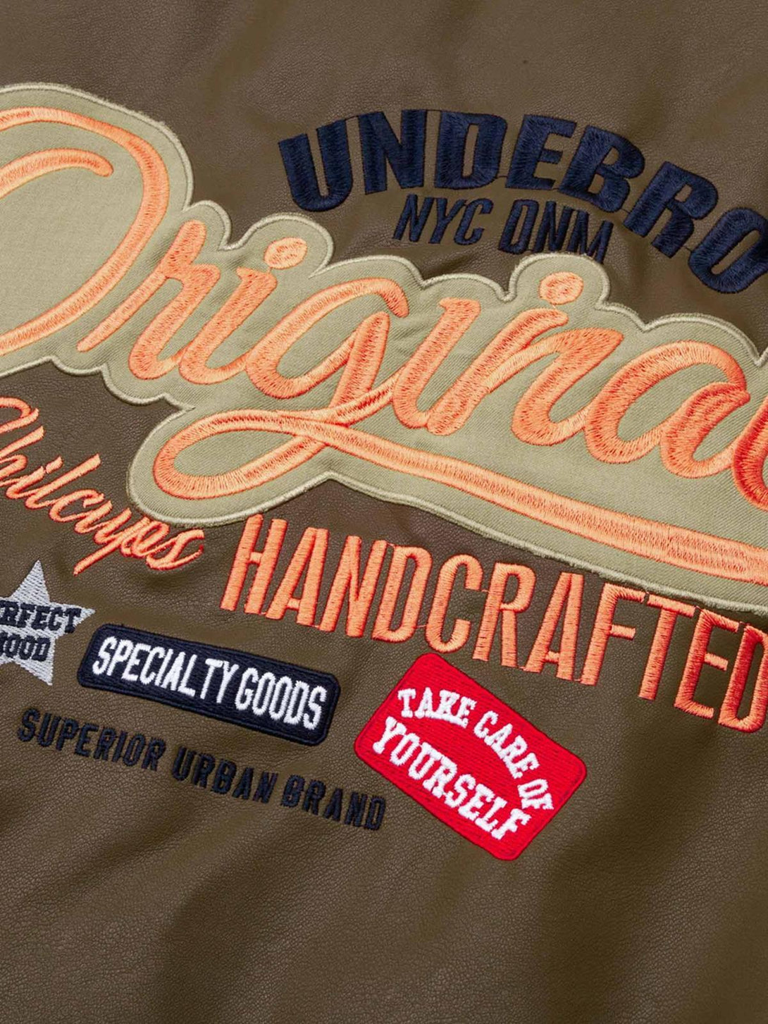 Embroidered lettering detail on TALISHKO leather bomber jacket, highlighting urban craftsmanship.