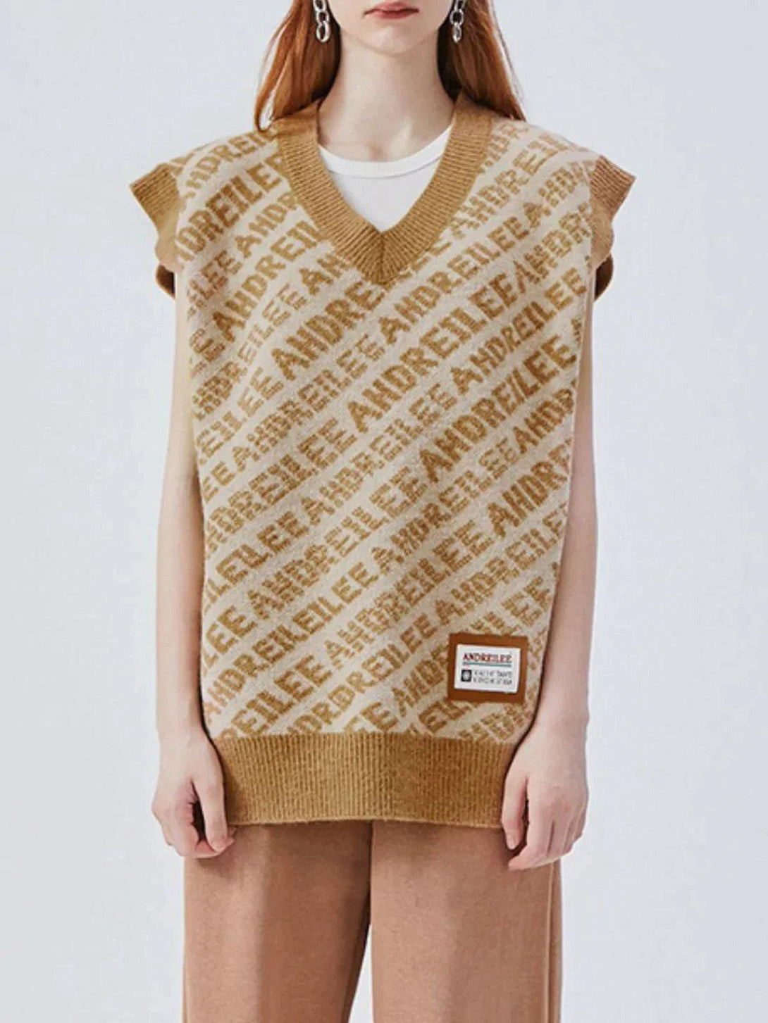Model wearing a beige letters graphic sweater vest by TALISHKO, featuring a relaxed fit.