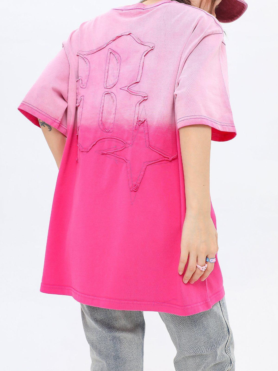 Back view of a pink vintage tee by TALISHKO, highlighting a bold letters graphic and relaxed fit.