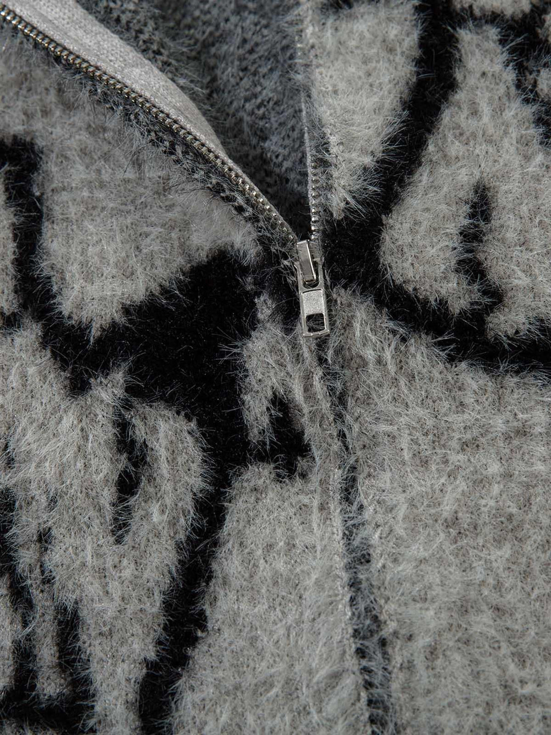 Intricate look at TALISHKO sweater's zip and fuzzy texture with bold lightning pattern.