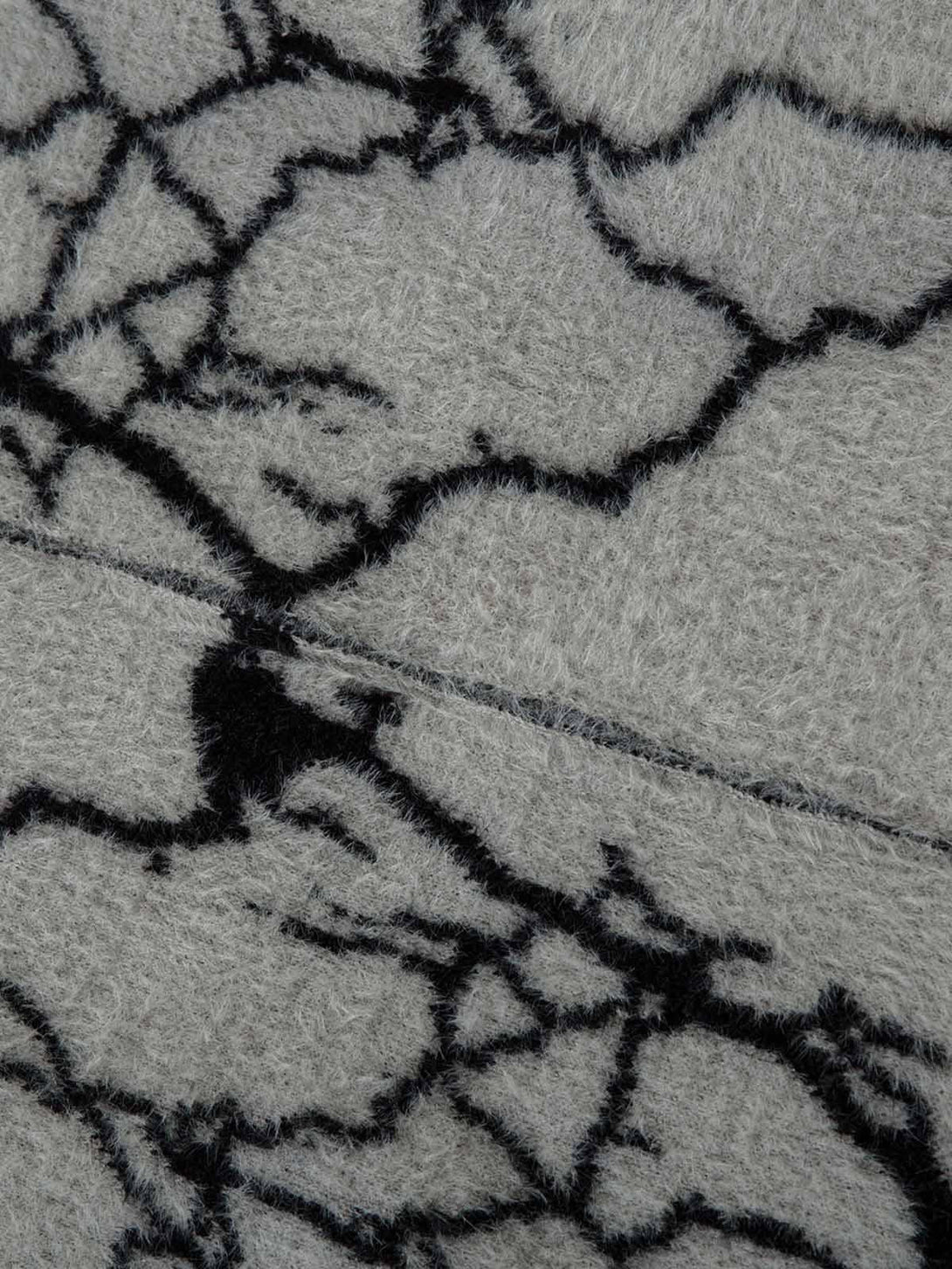 Detailed fabric and stitching of TALISHKO's sweater, featuring a bold lightning pattern.