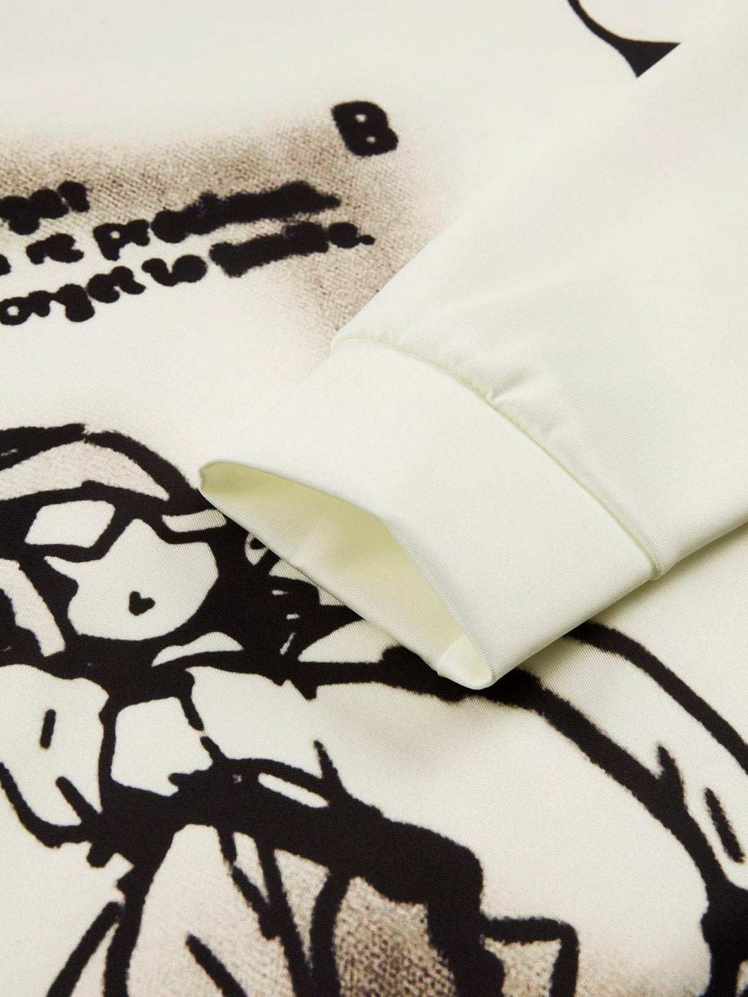 A close-up of TALISHKO hoodie sleeve, highlighting abstract character design and smooth fabric.