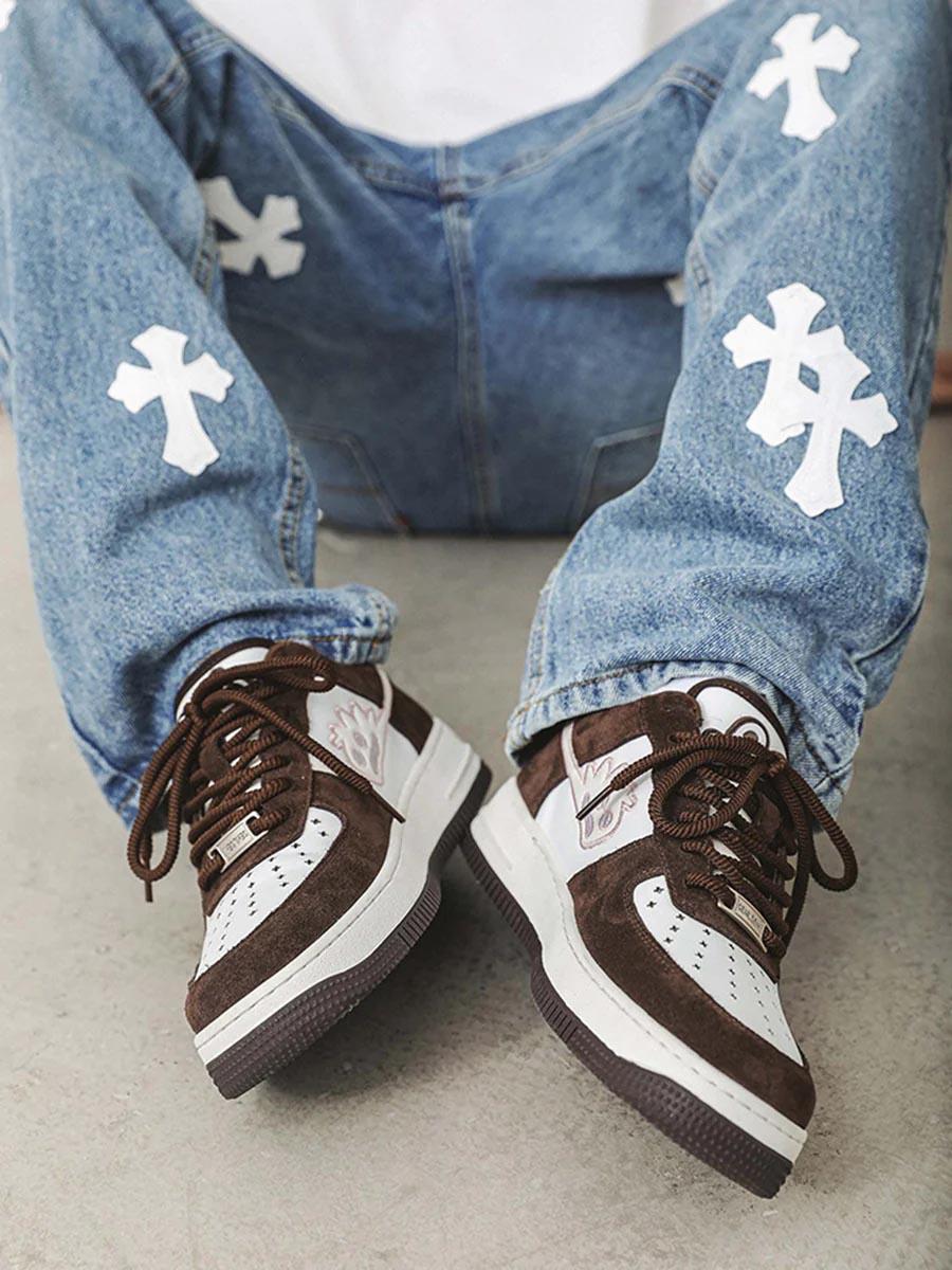 TALISHKO skate sneakers paired with cross-embellished jeans, showcasing casual street style.