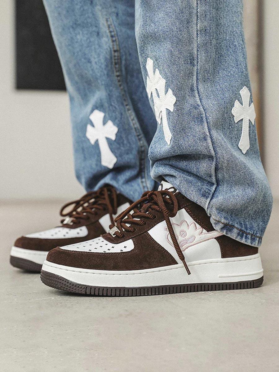 TALISHKO skate sneakers in brown and white, styled with cross-patterned jeans for a trendy look.