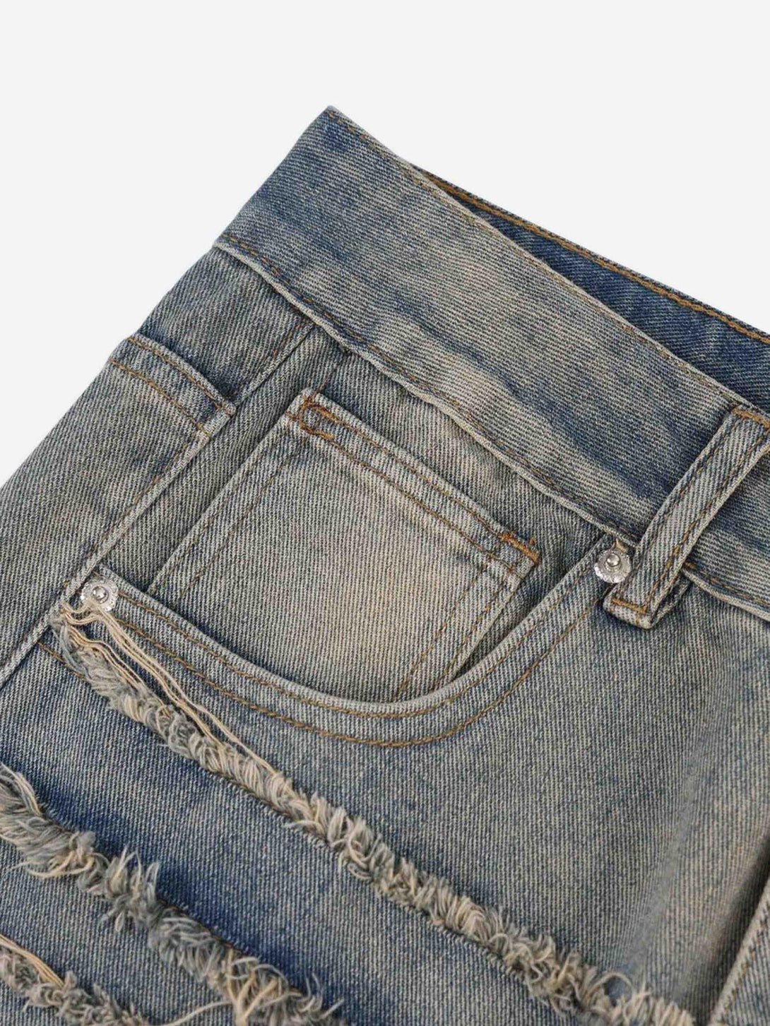 A detailed view of TALISHKO jeans showcasing frayed detailing and unique texture.