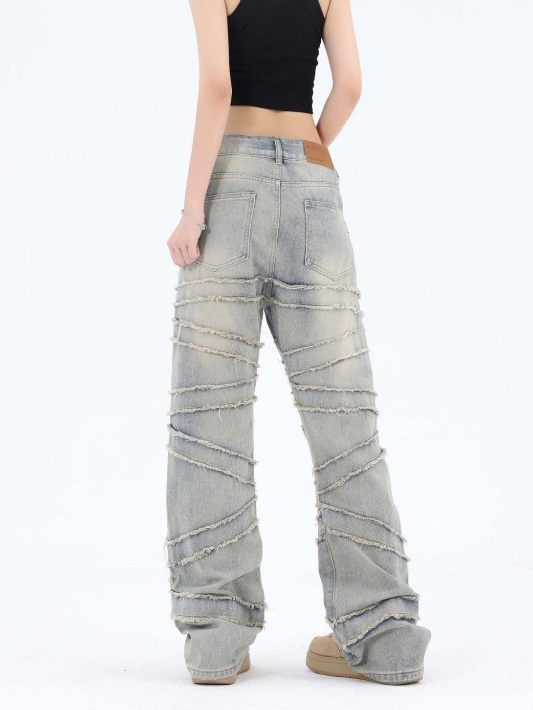 Back view of TALISHKO wide-leg jeans with frayed diagonal details, perfect for a bold look.