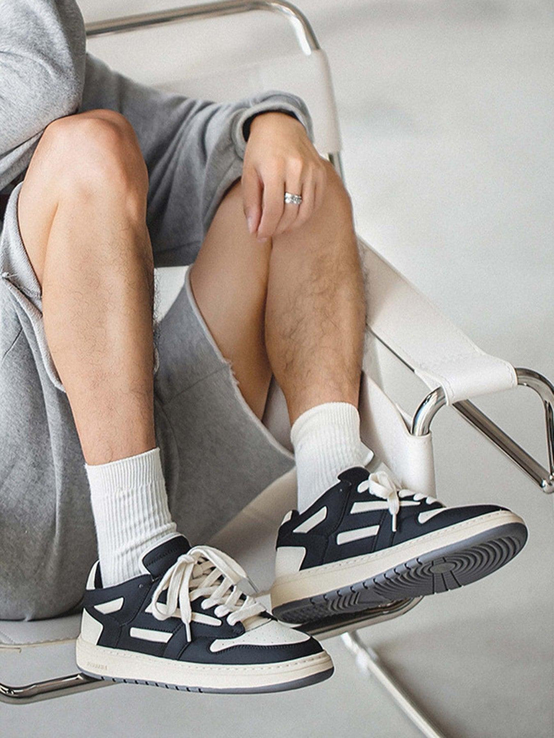 TALISHKO low-top sneakers in black and white, paired with casual gray shorts for stylish comfort.