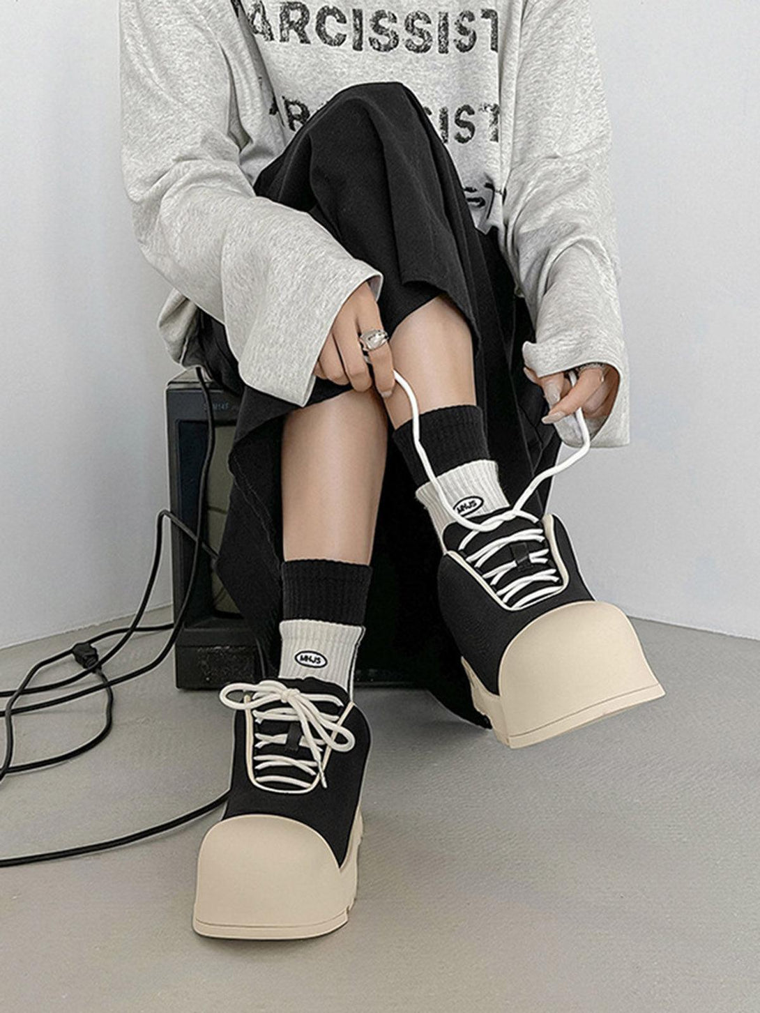 Model wearing TALISHKO low top canvas platform sneakers with bold soles and a casual outfit.