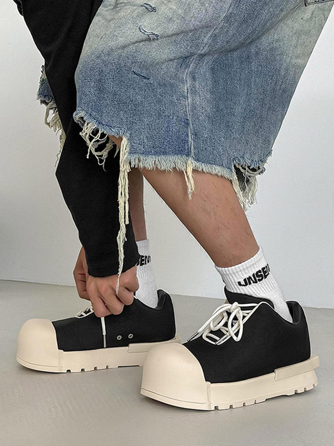 TALISHKO low top canvas platform sneakers with chunky soles, styled with distressed denim.