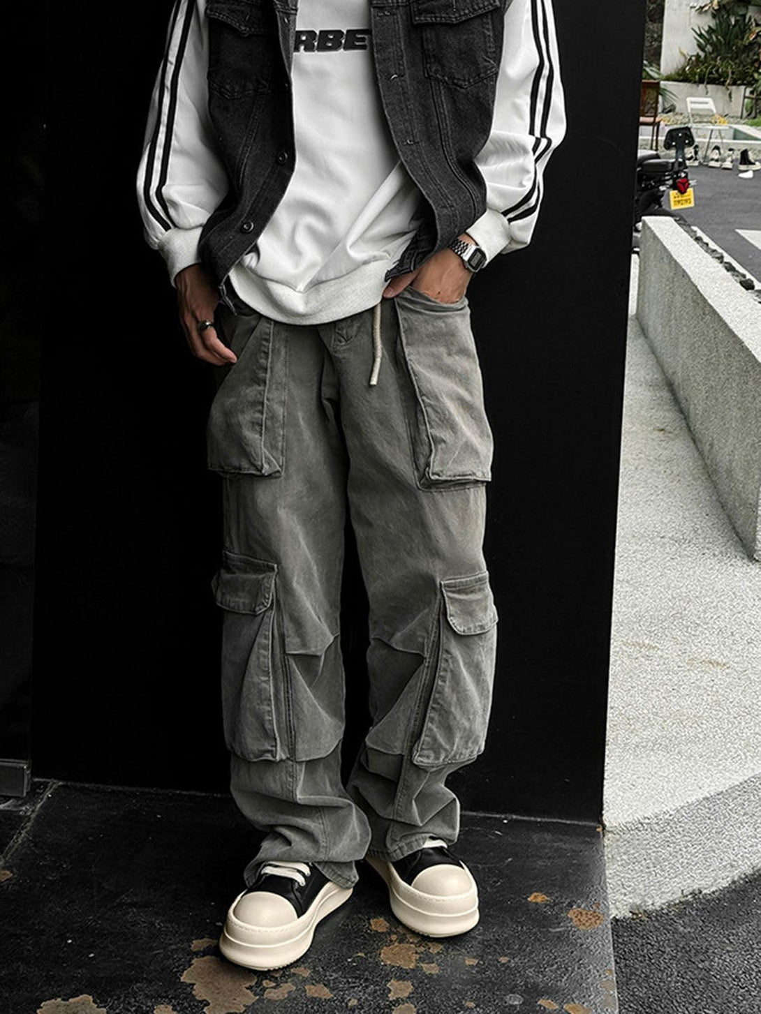 TALISHKO's chunky low-top sneakers in cream and black, styled with casual gray cargo pants.