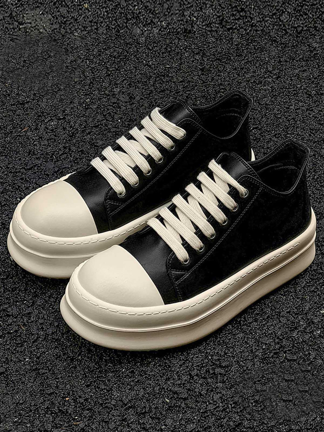 TALISHKO chunky low-top sneakers in black and cream, showcasing a bold, modern design.