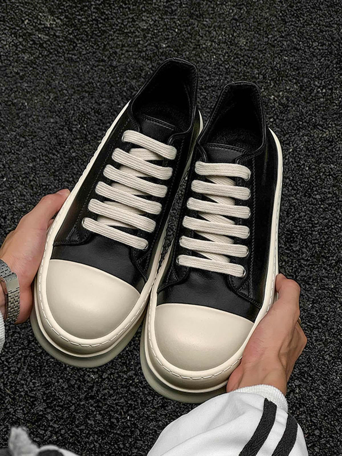 TALISHKO's low-top sneakers in black and cream, featuring chunky soles and bold laces.