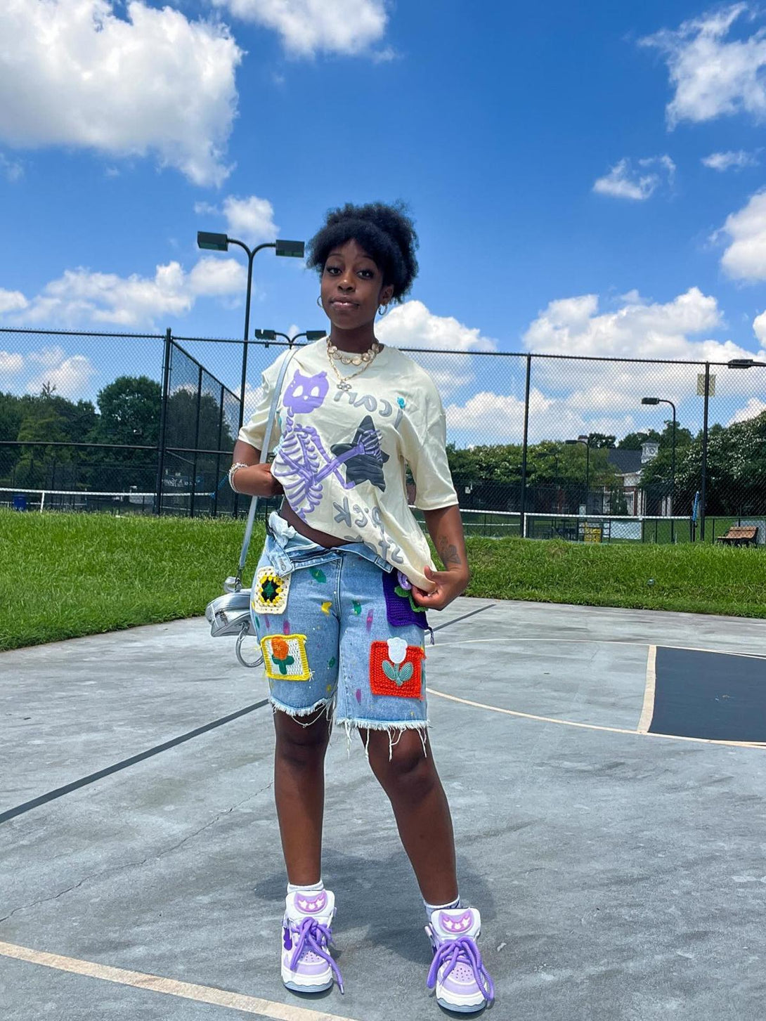 TALISHKO T-shirt with a skeleton graphic paired with patchwork shorts on a sunny day.