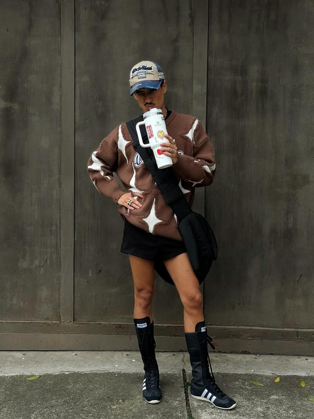 Model wearing TALISHKO's brown star-pattern sweater with tassel details, styled with boots.