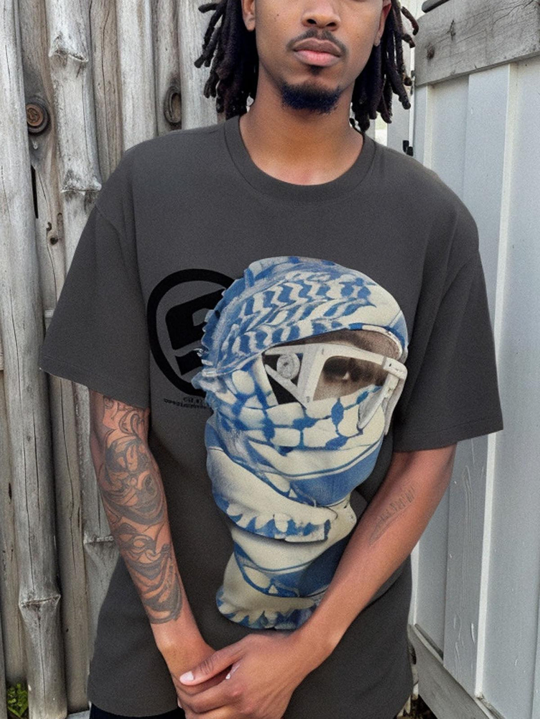 Model wearing TALISHKO's dark T-shirt with a bold masked portrait graphic, perfect for casual wear.