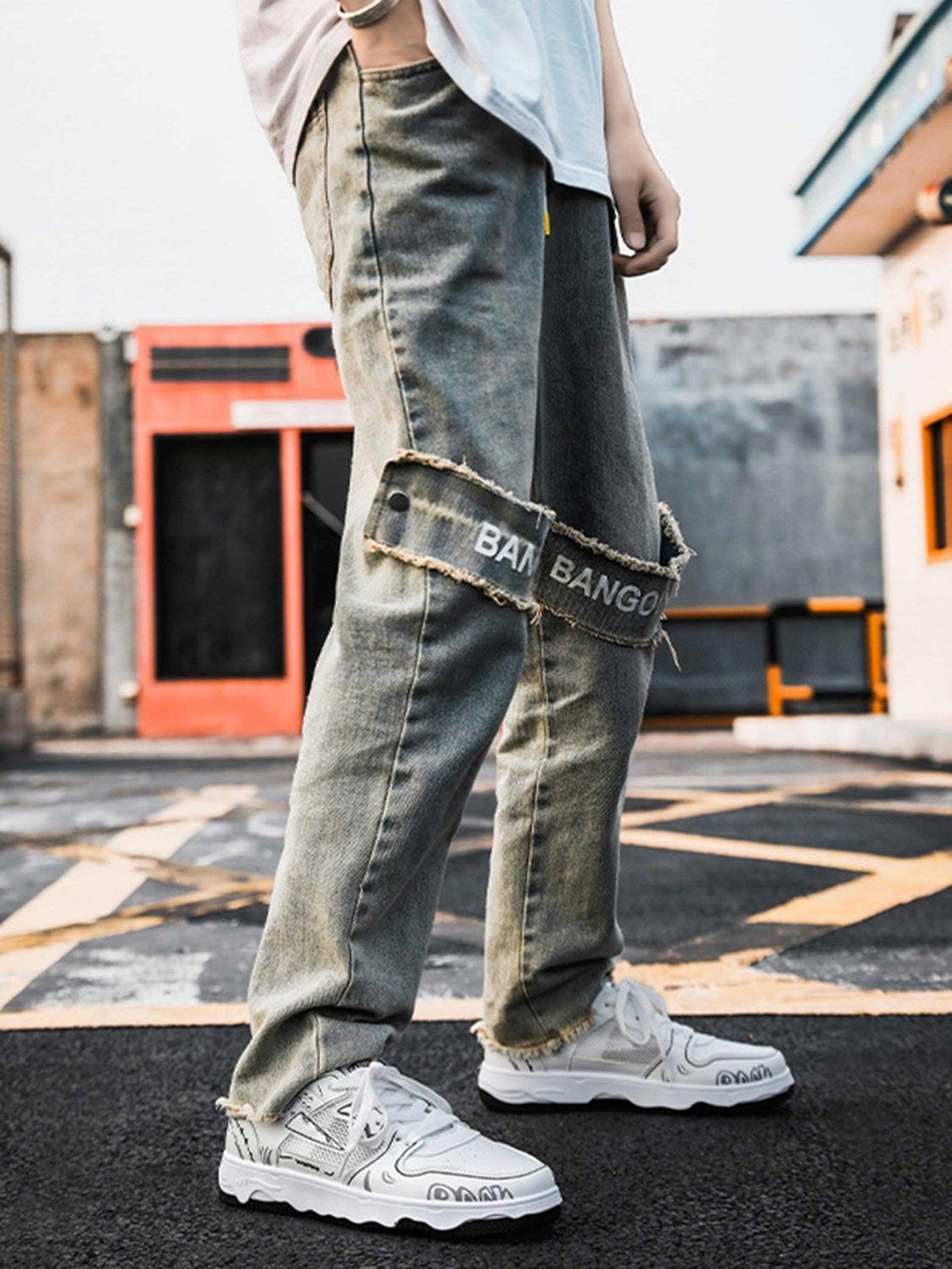 TALISHKO denim pants styled with white mesh board shoes featuring bold graphic accents.