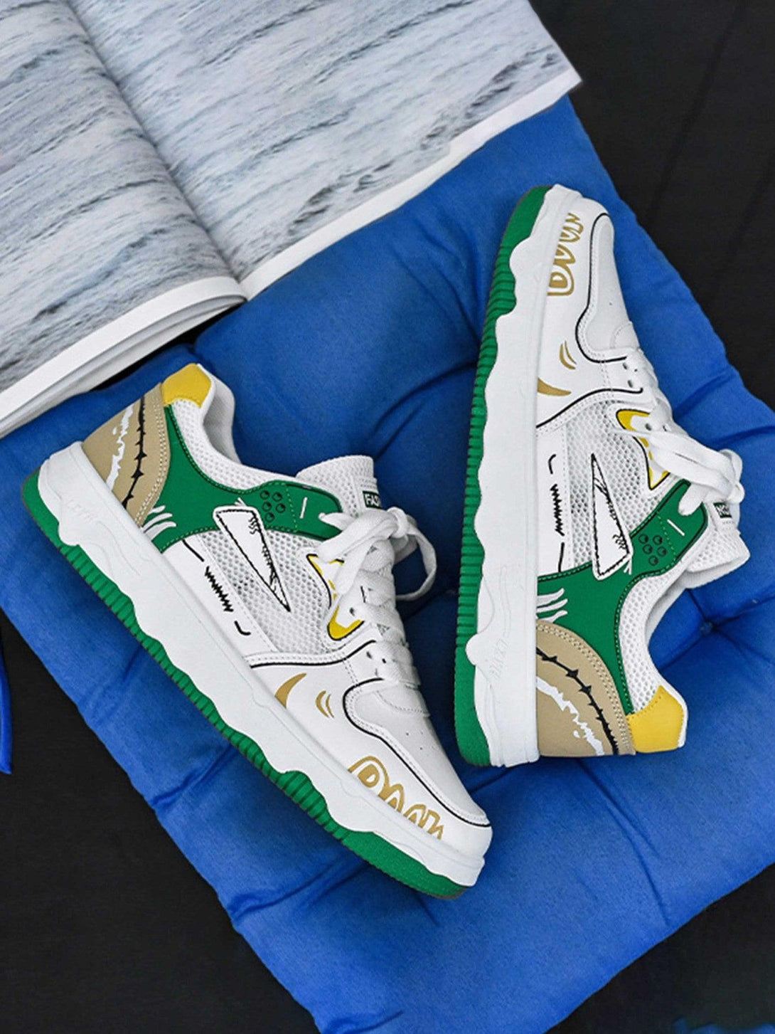 TALISHKO's board shoes feature vibrant green and yellow graphics, displayed on a vivid blue cushion.