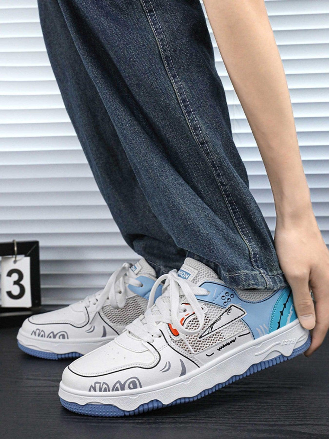 Casual denim paired with TALISHKO's mesh board shoes, showcasing bold graphics and blue accents.