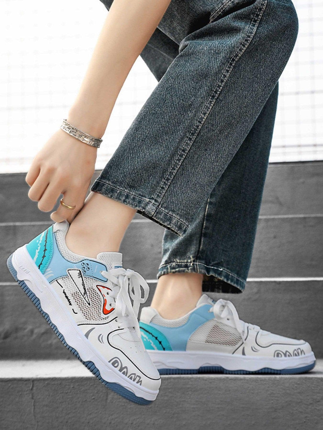 TALISHKO board shoes with blue mesh and graphic details, styled with casual denim for a trendy look.