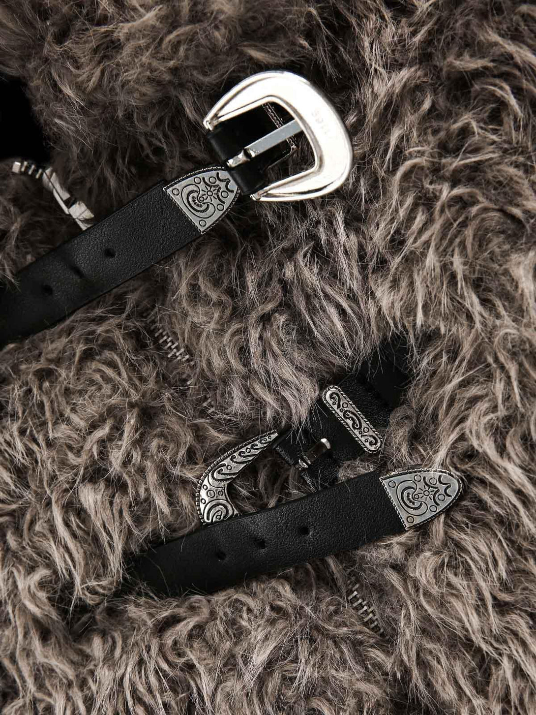 Intricate detailing of metal leather buckles on textured faux fur, crafted by TALISHKO.
