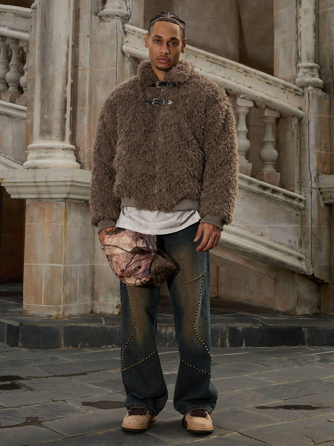 Model styled in a warm faux fur jacket with leather buckles by TALISHKO, paired with denim.