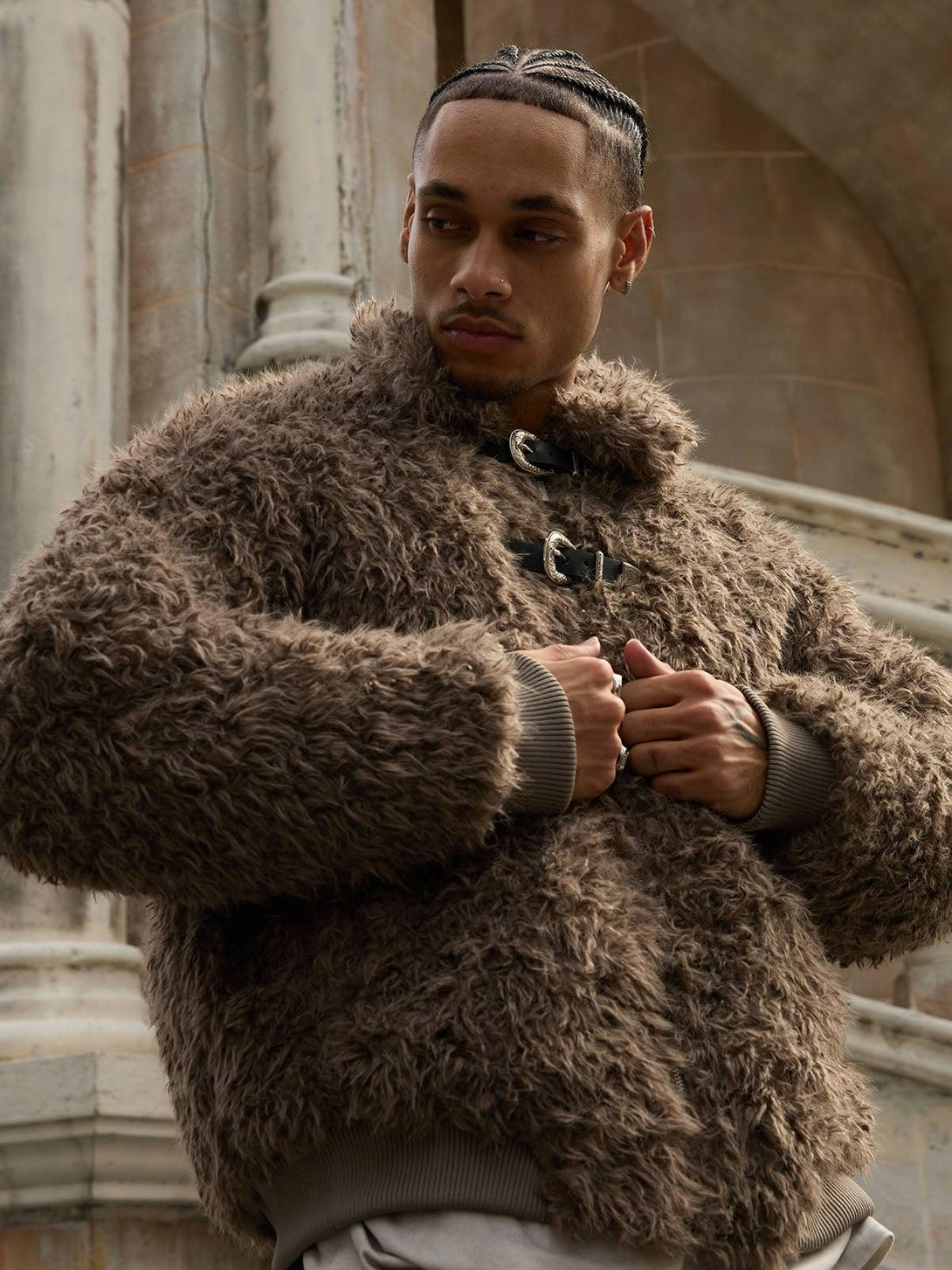 Model styled in a plush faux fur jacket with metal leather buckles by TALISHKO.