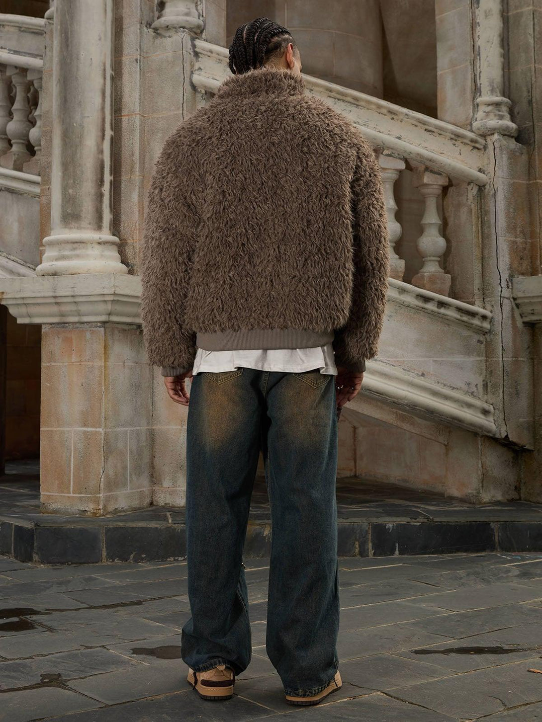Model in a plush brown faux fur jacket by TALISHKO, paired with loose-fit denim jeans.
