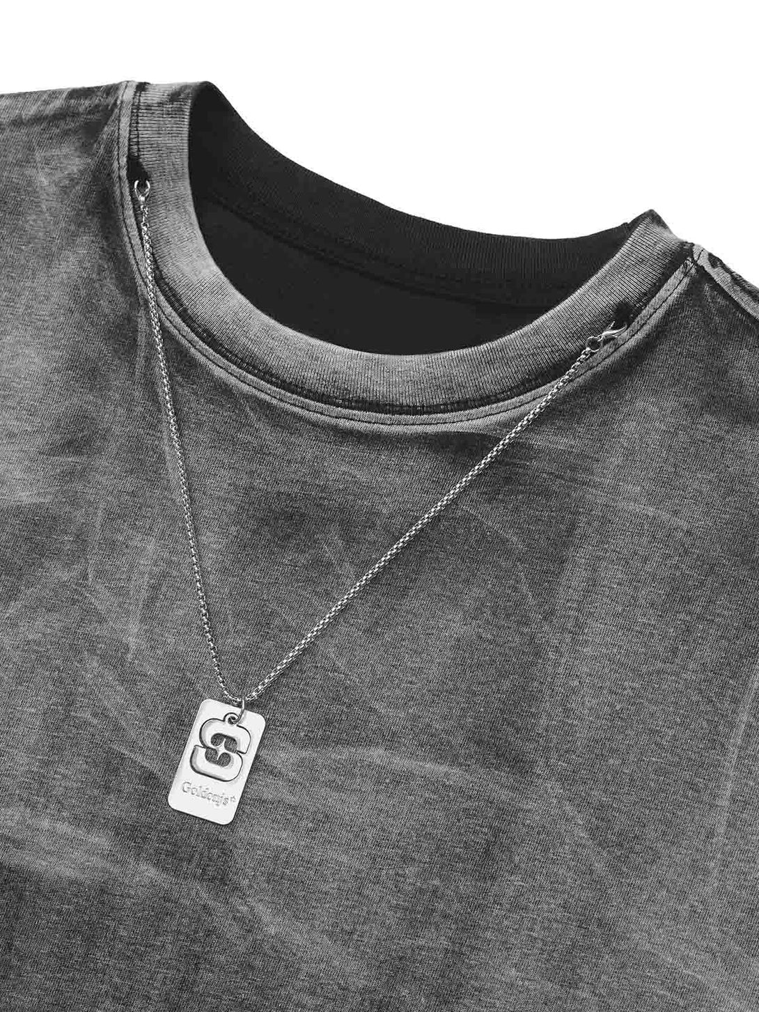 Close-up of TALISHKO street rap T-shirt with a metal tag, showcasing unique texture and style.