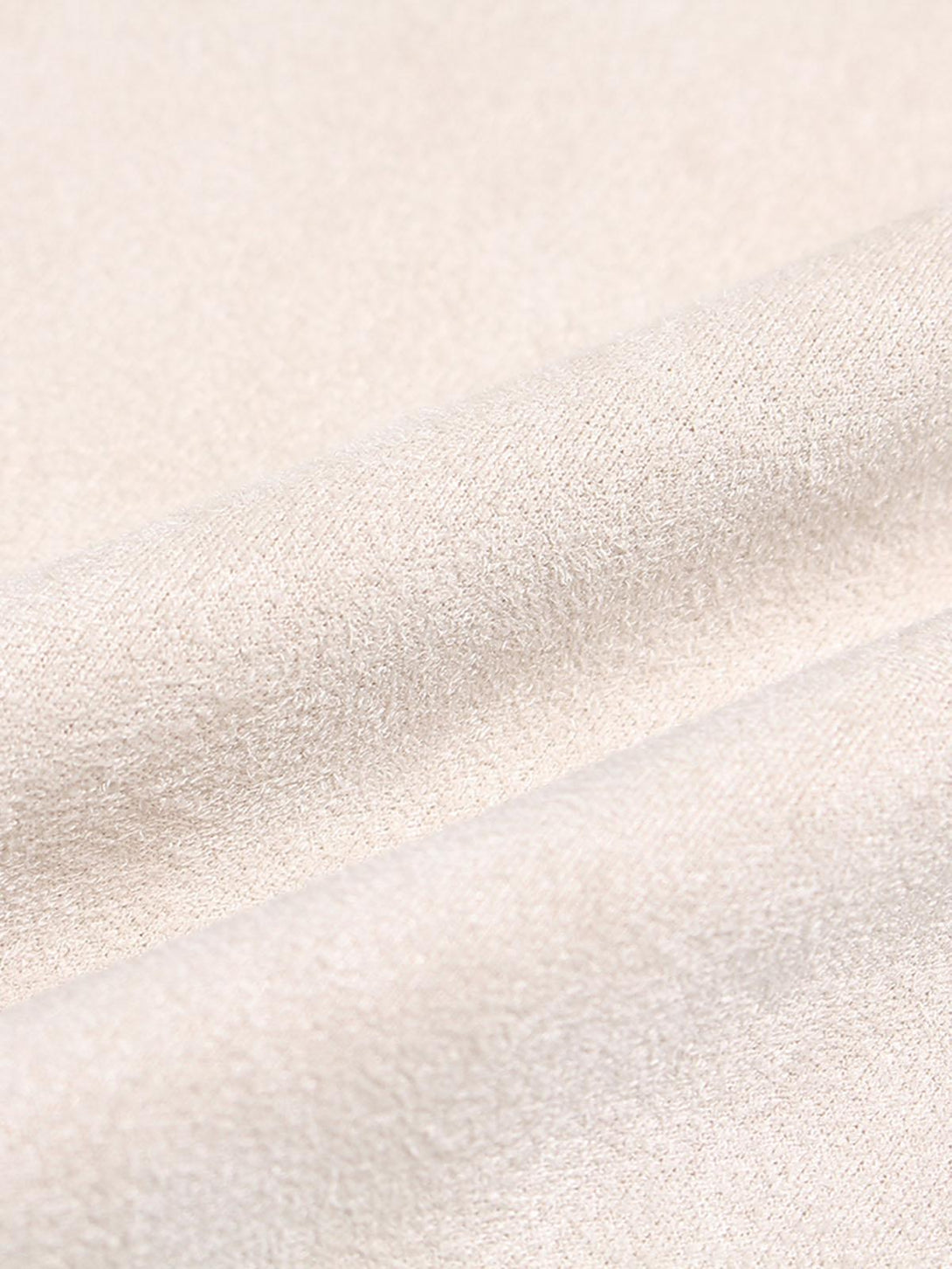 Zoomed-in texture of TALISHKO's beige suede fabric, highlighting its soft and luxurious feel.