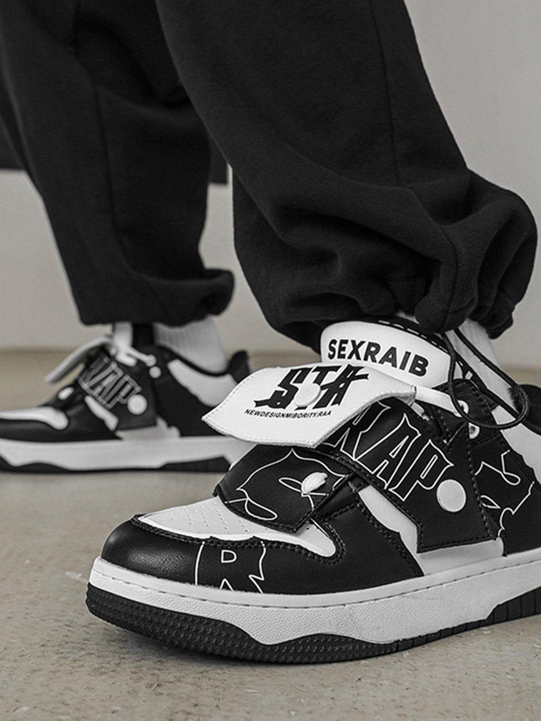 TALISHKO skate shoes in black and white, showcasing bold color blocking on a model's feet.