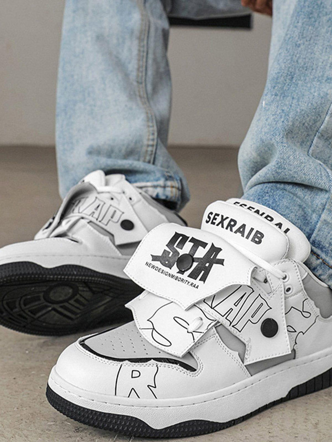 TALISHKO mid-top skate shoes with graphic design details, worn with light blue jeans.