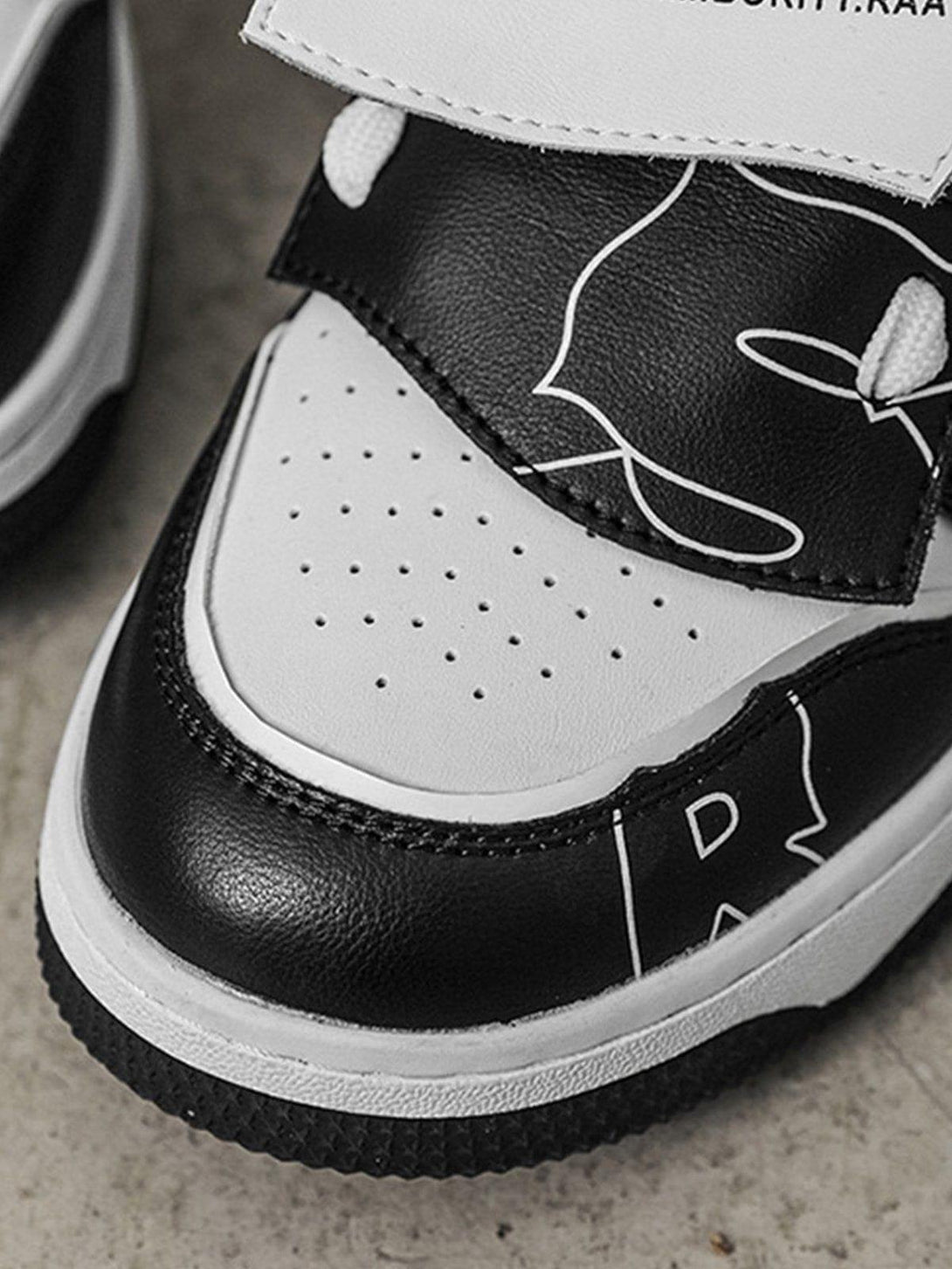 A close-up of TALISHKO mid-top skate shoes, highlighting black and white color blocking design.