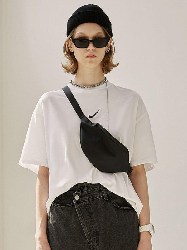 Model wearing a stylish white tee and black mini crossbody waist bag by TALISHKO.