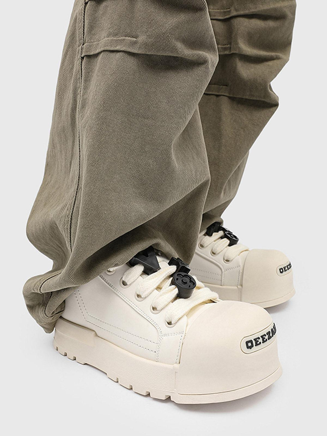 TALISHKO's monochrome chunky tread sneakers paired with olive pants, highlighting unique style.